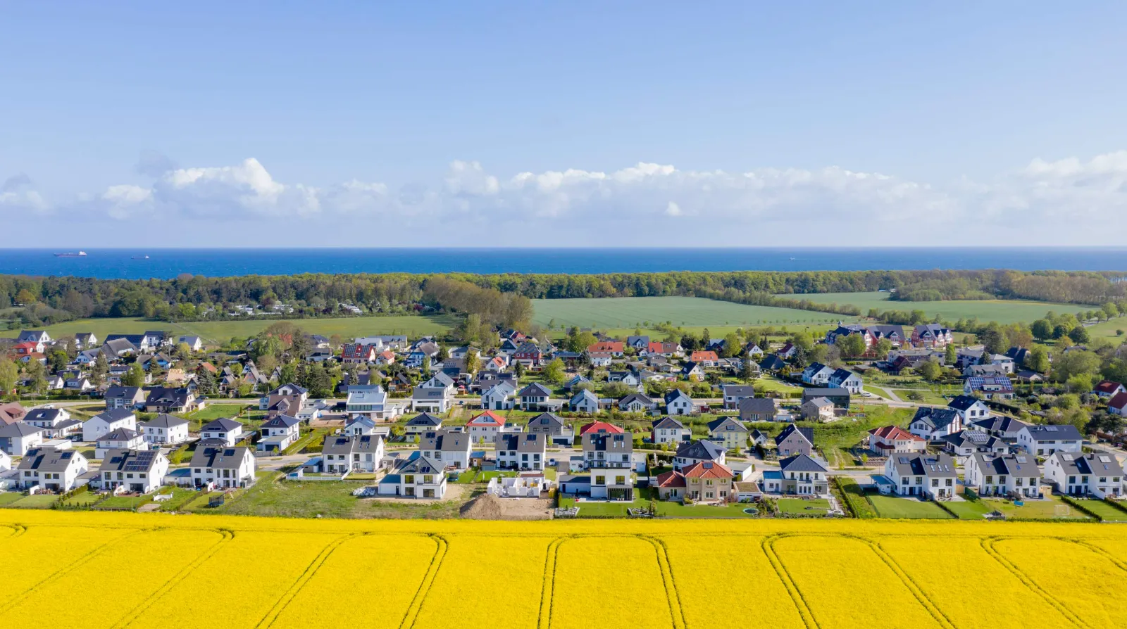 Wohnsiedlung zwischen Rapsfeld und Ostsee bei Rostock aus der Luft